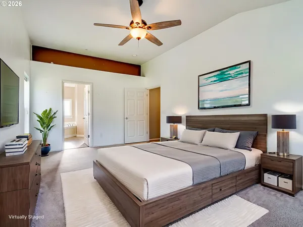 a spacious bedroom with a large bed a chandelier and a couch