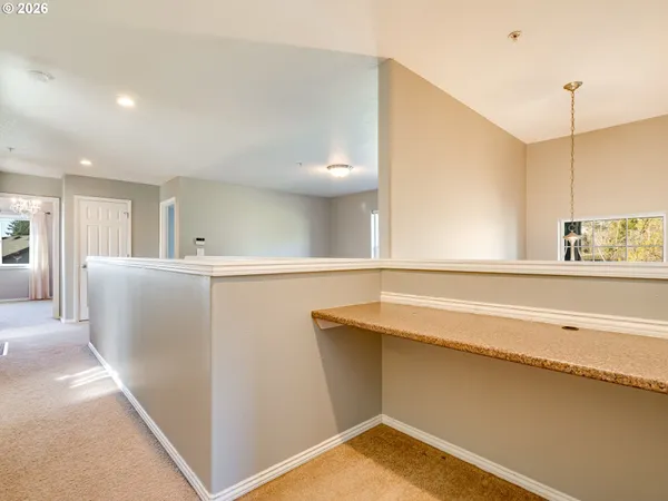a view of a kitchen with kitchen island a sink wooden floor and a chandelier