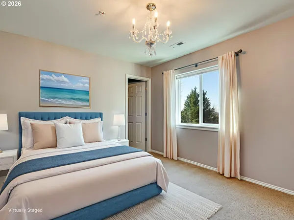 a bedroom with a large bed and a chandelier