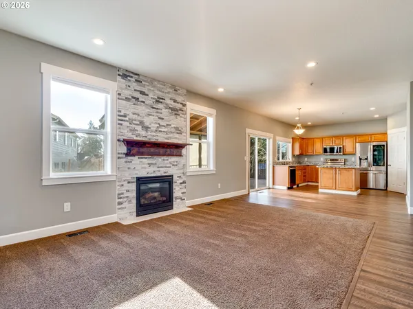 a view of a livingroom with a fireplace cabinet and windows