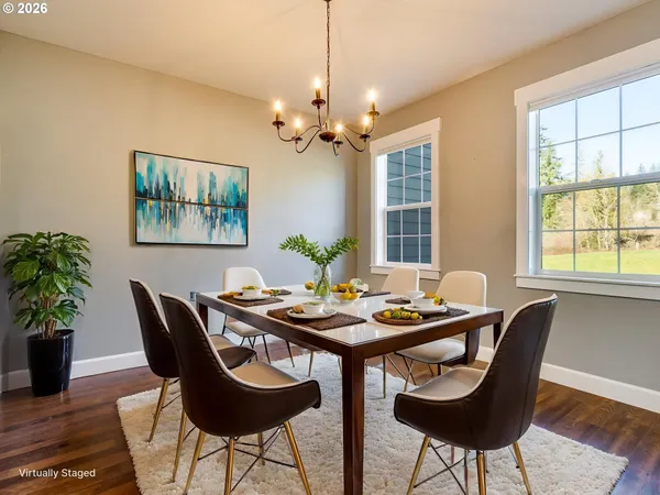 a dining room with furniture potted plants and wooden floor