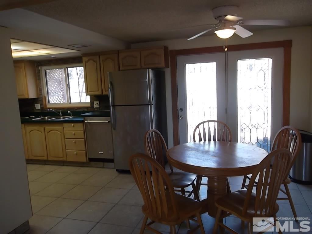1575 Carlin Street Reno, NV 89503 - Photo 9 of 17 a kitchen with stainless steel appliances granite countertop a dining table chairs refrigerator a sink and dishwasher