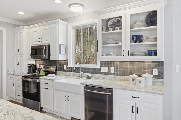 a kitchen with stainless steel appliances granite countertop a sink stove and cabinets