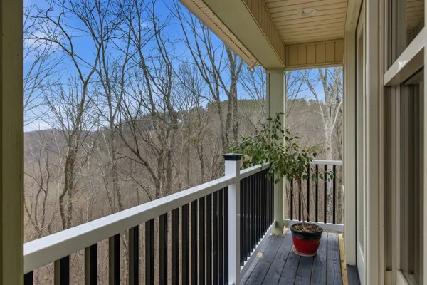a view of a balcony with wooden floor and floor to ceiling window
