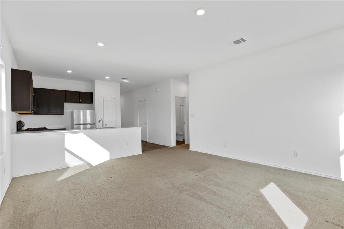 14320 Tordillo Drive Elgin, TX 78621 - Photo 11 of 19 Unfurnished living room with light carpet and recessed lighting