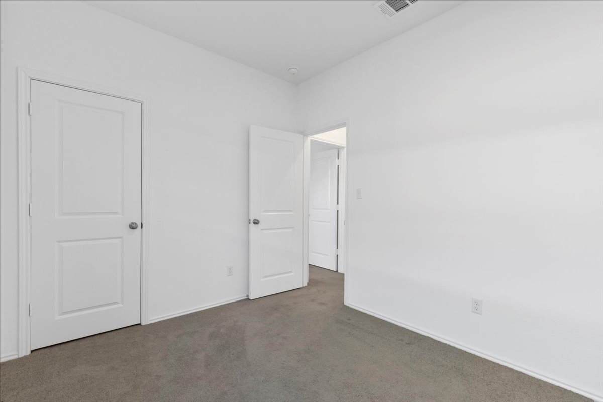14320 Tordillo Drive Elgin, TX 78621 - Photo 14 of 19 Unfurnished bedroom featuring dark colored carpet and baseboards