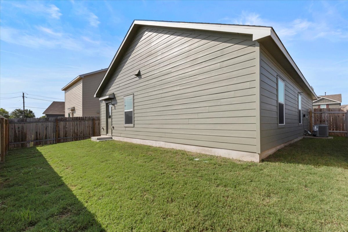 14320 Tordillo Drive Elgin, TX 78621 - Photo 18 of 19 View of property exterior featuring a fenced backyard and a central air condition unit