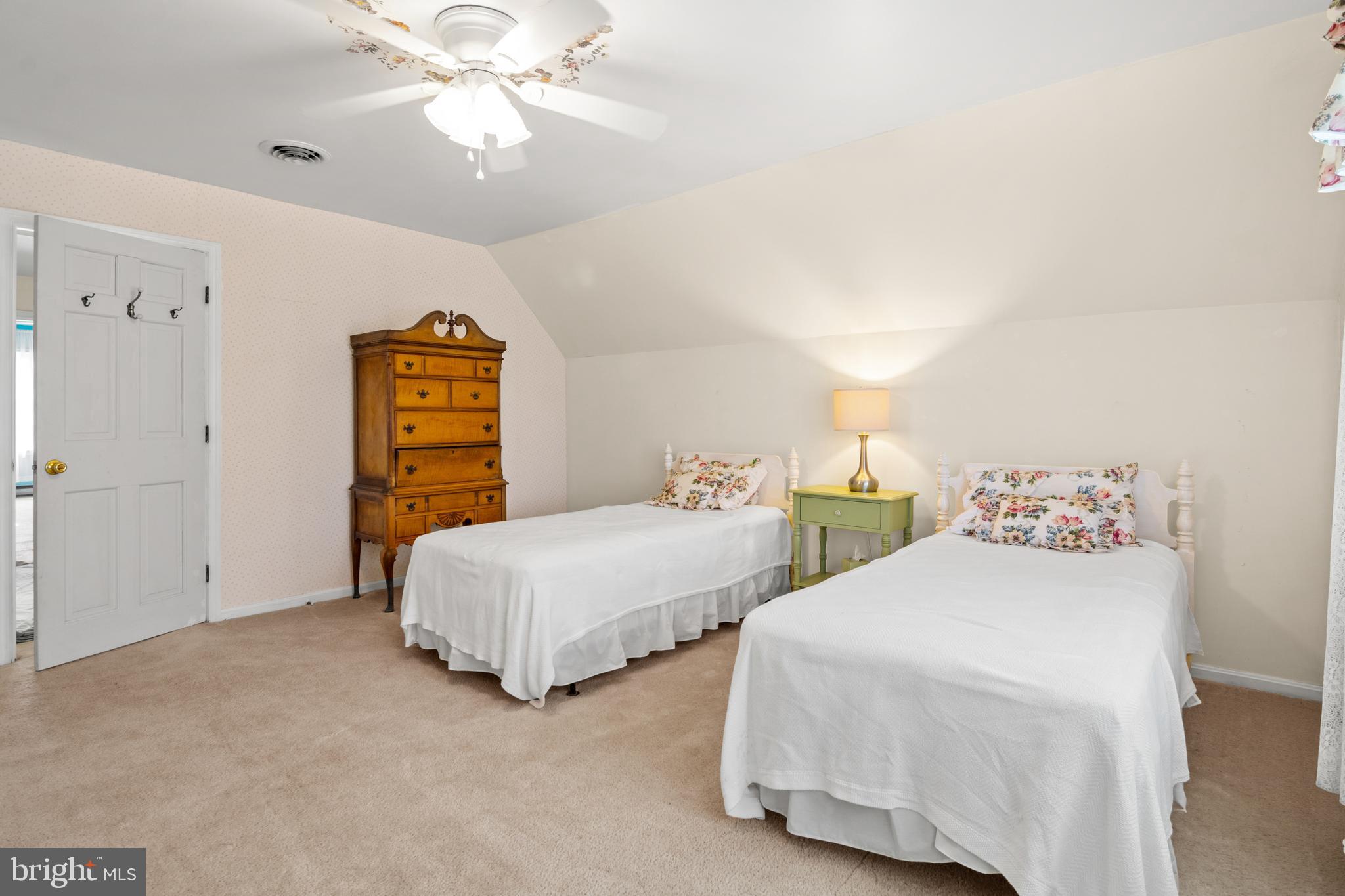 22539 Indian Point Road Bozman, MD 21612 - Photo 29 of 66 a bedroom with two bed and a chandelier