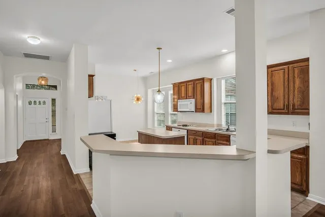 an empty room with windows and chandelier fan