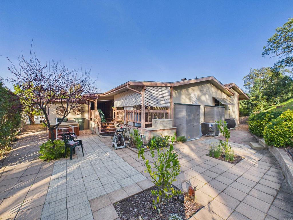 18218 Paradise Mountain Road, Unit 220 Valley Center, CA 92082 - Photo 6 of 48 a view of a house with a small yard and a large tree