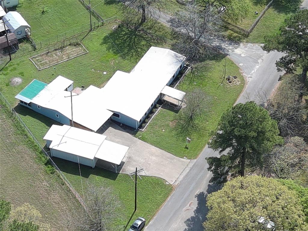 an aerial view of a house with a yard and pool