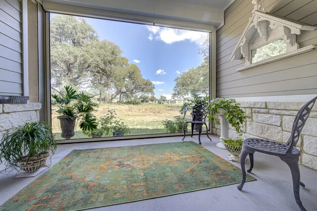 a view of a porch with a table and chairs and potted plants