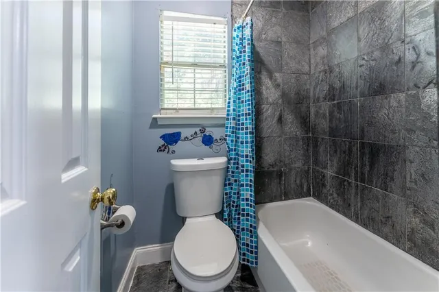 a white toilet sitting next to a bath tub