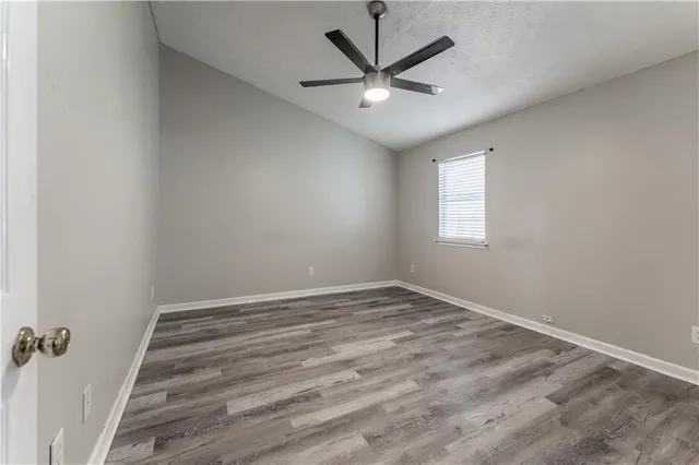 an empty room with a window and a fan