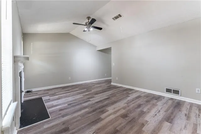 a view of a room with wooden floor and ceiling fan