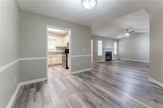 a view of a big room with wooden floor and windows