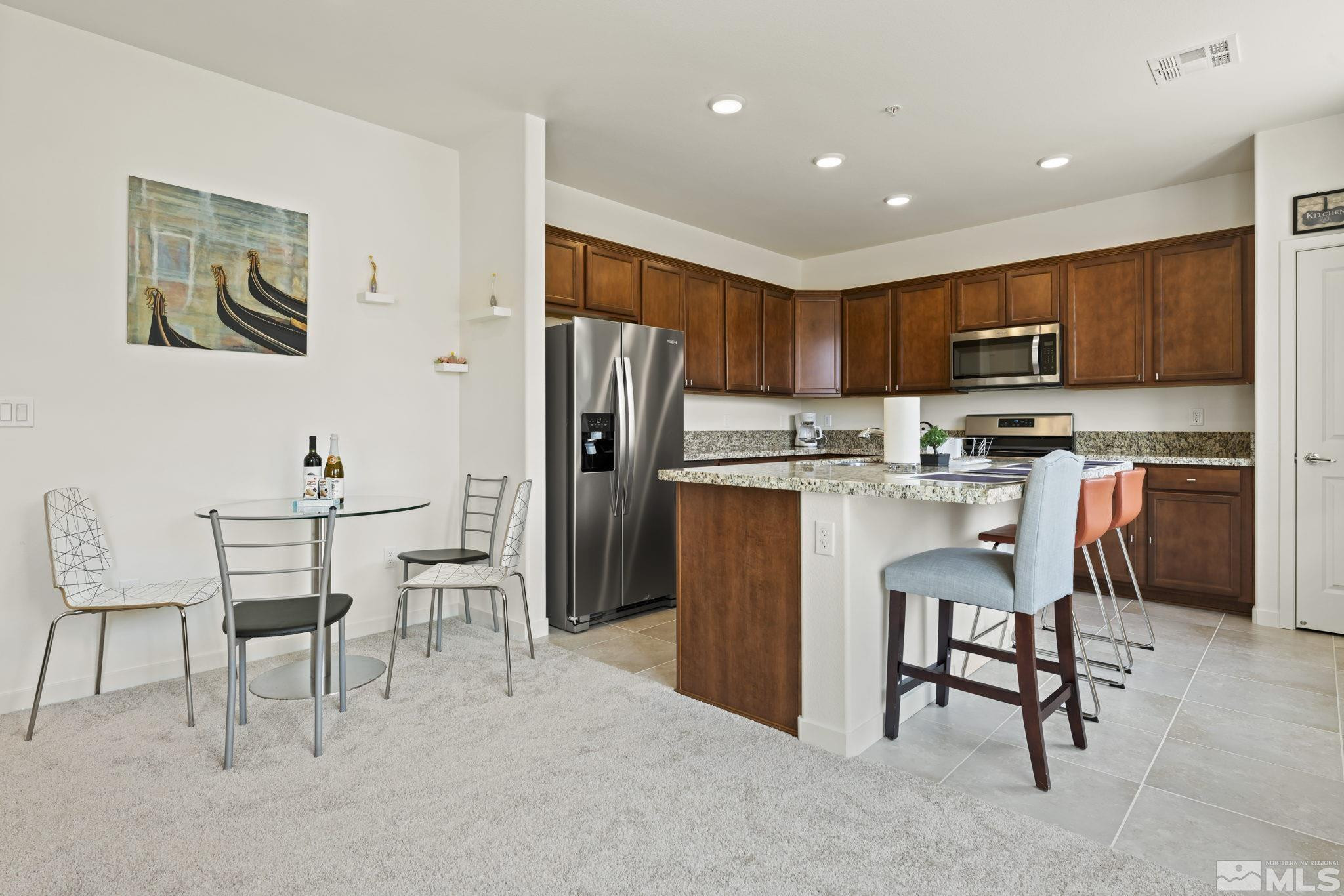 4920 Little Rock Way Sun Valley, NV 89433 - Photo 11 of 37 a kitchen with stainless steel appliances granite countertop a refrigerator and a stove top oven