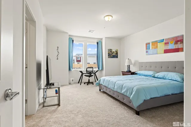 a bedroom with a bed and a flat tv screen on wall