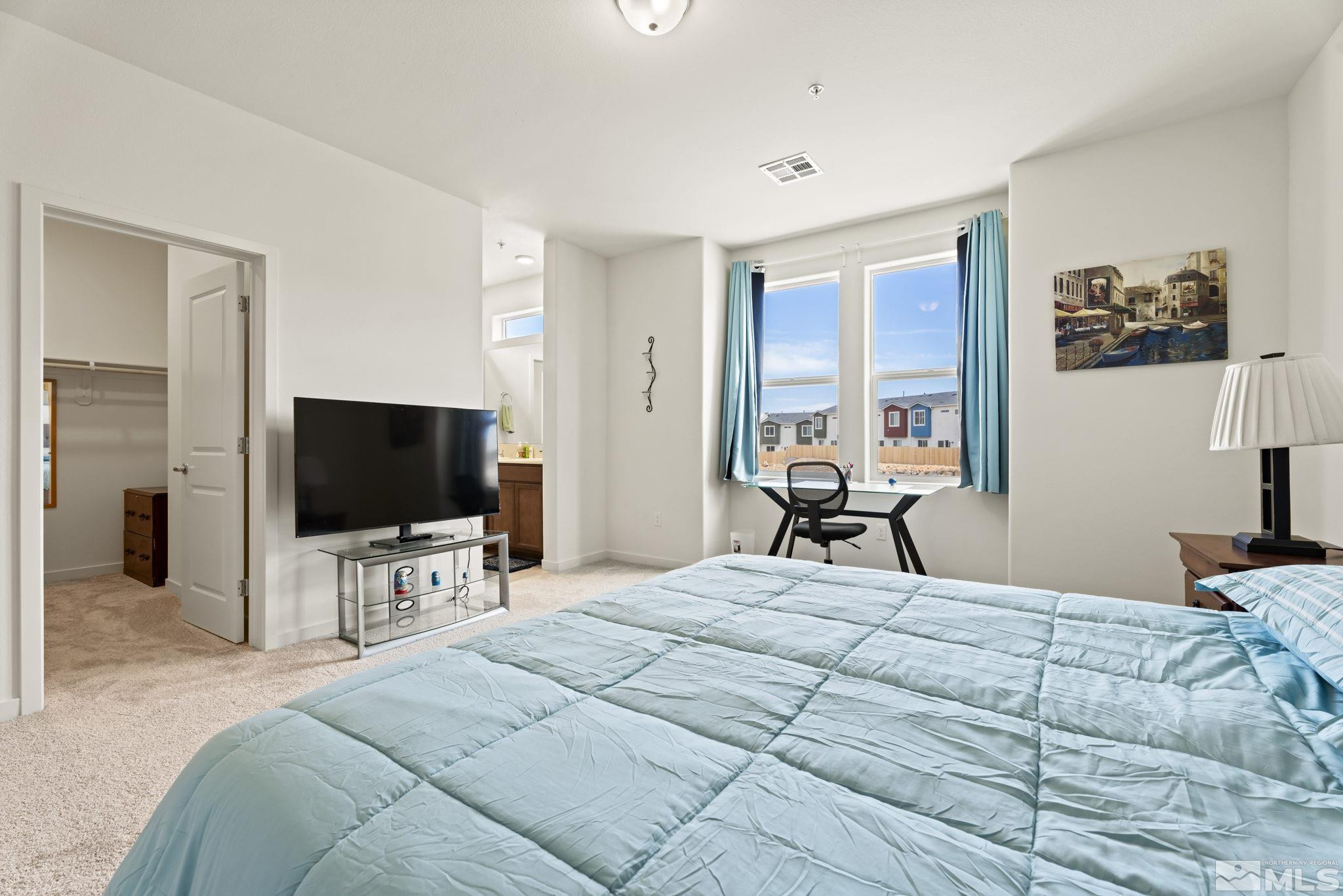 4920 Little Rock Way Sun Valley, NV 89433 - Photo 16 of 37 a bedroom with a bed and a flat tv screen on wall