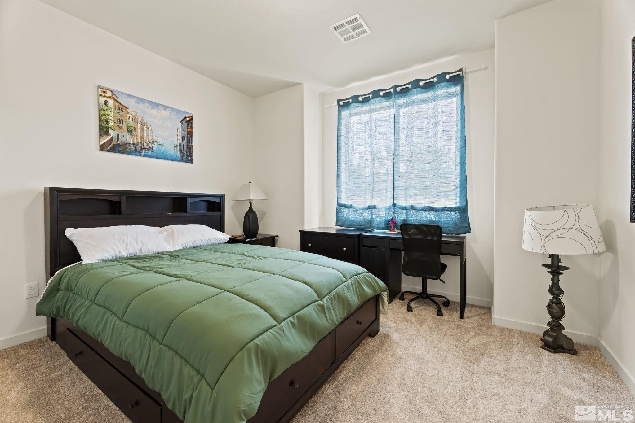 4920 Little Rock Way Sun Valley, NV 89433 - Photo 20 of 37 a bedroom with a bed a table and a window