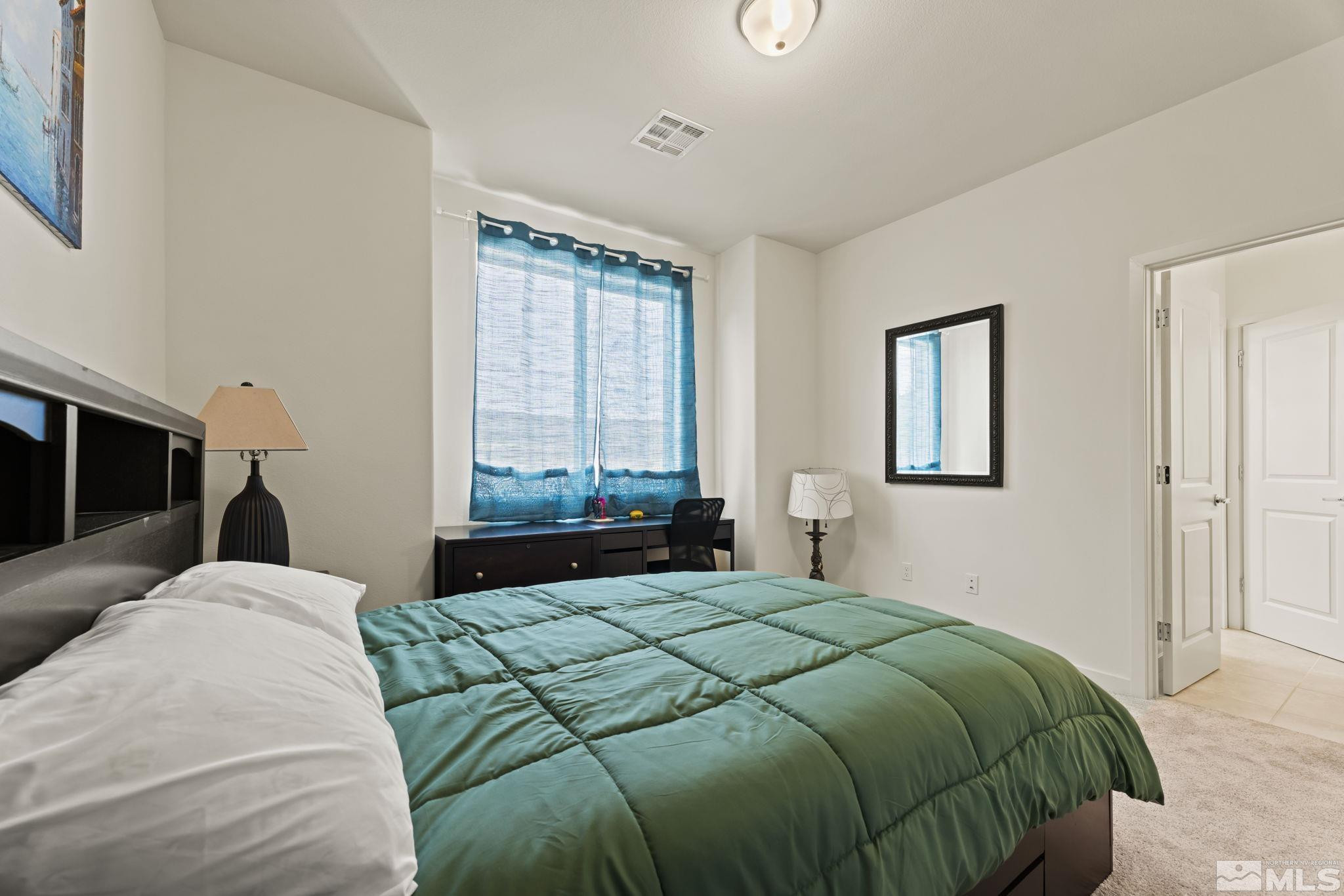 4920 Little Rock Way Sun Valley, NV 89433 - Photo 21 of 37 a bedroom with a large bed and a window