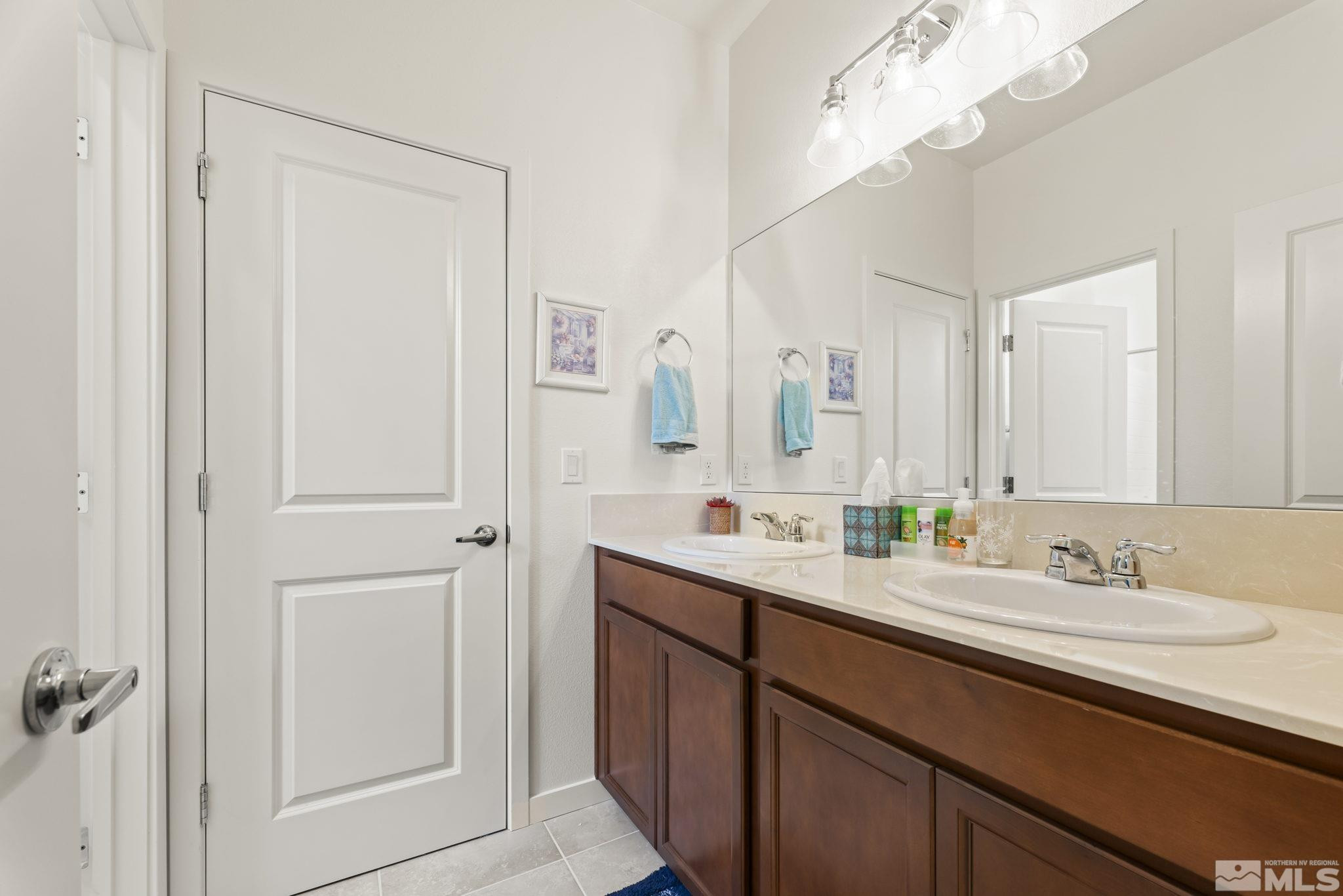 4920 Little Rock Way Sun Valley, NV 89433 - Photo 22 of 37 a bathroom with a double vanity sink and a mirror