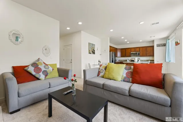 a living room with furniture and a view of kitchen