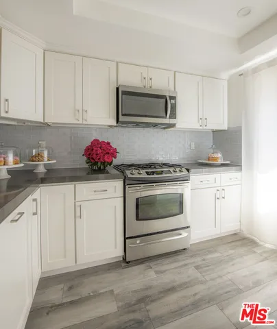 a kitchen with white cabinets stainless steel appliances and sink