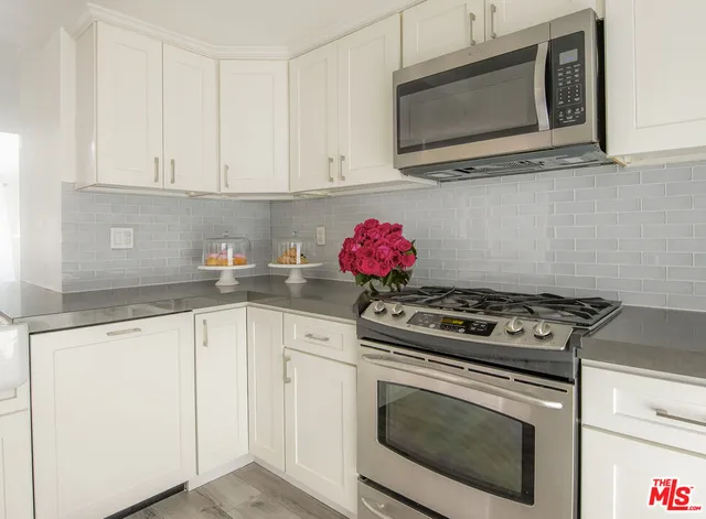 a kitchen with granite countertop a stove and a microwave