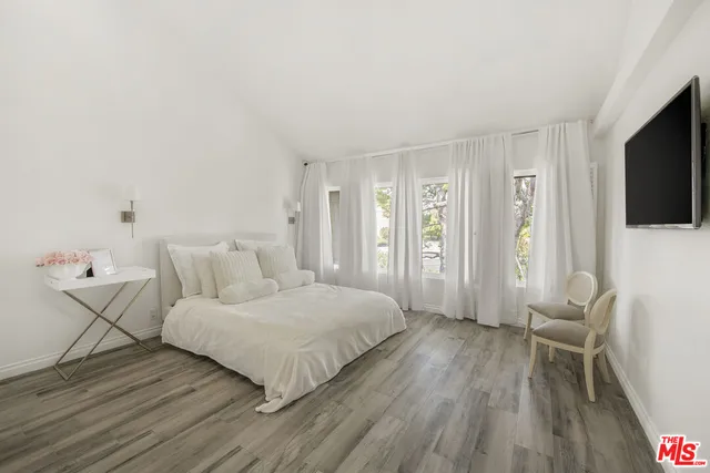 a bedroom with a bed and a flat screen tv