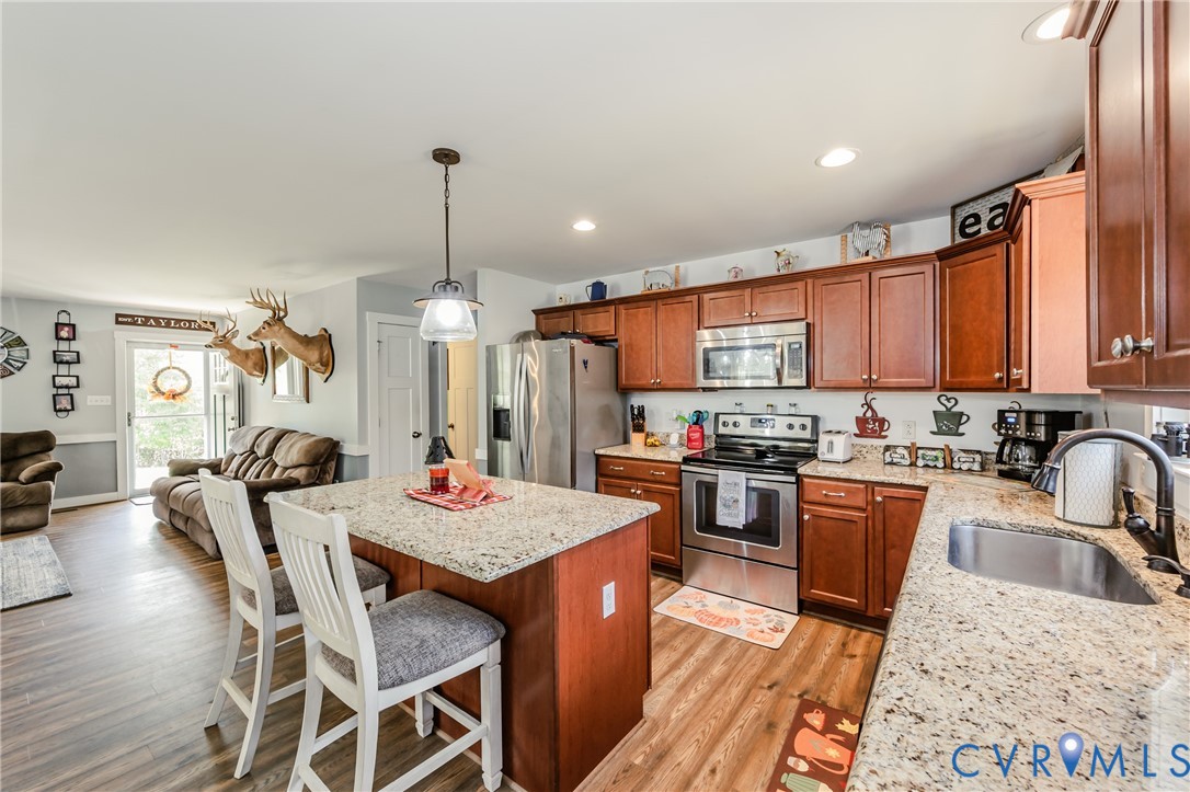 915 Manchester Road Bumpass, VA 23024 - Photo 19 of 49 a kitchen with stainless steel appliances granite countertop a kitchen island hardwood floor sink stove dining table and chairs
