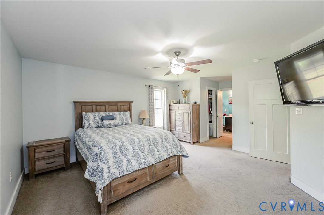 915 Manchester Road Bumpass, VA 23024 - Photo 21 of 49 a bedroom with a bed and a flat tv screen on dresser