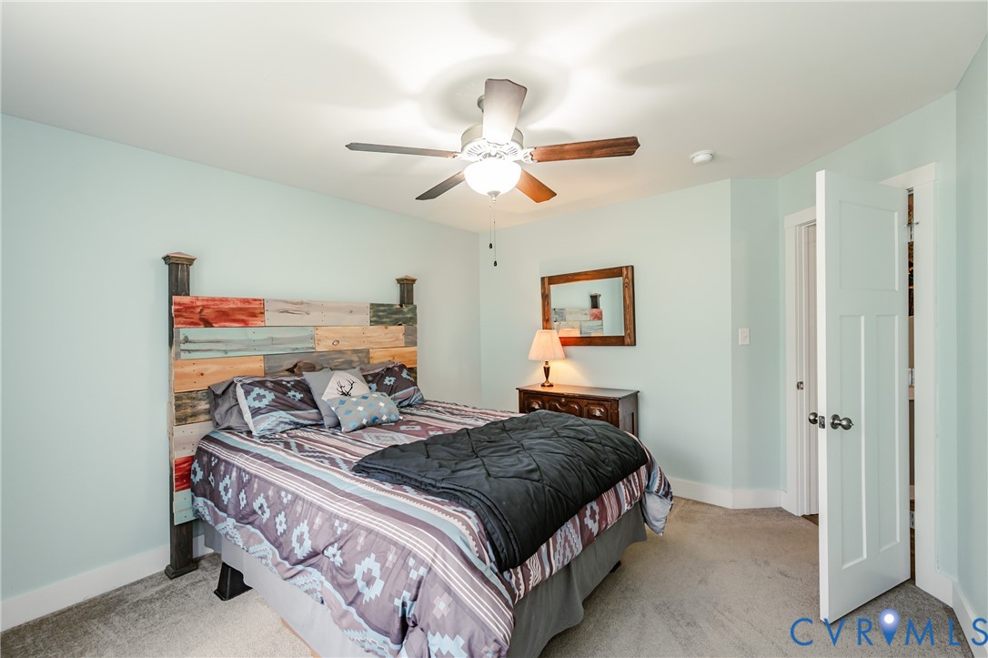 915 Manchester Road Bumpass, VA 23024 - Photo 31 of 49 a bedroom with a bed and a chandelier