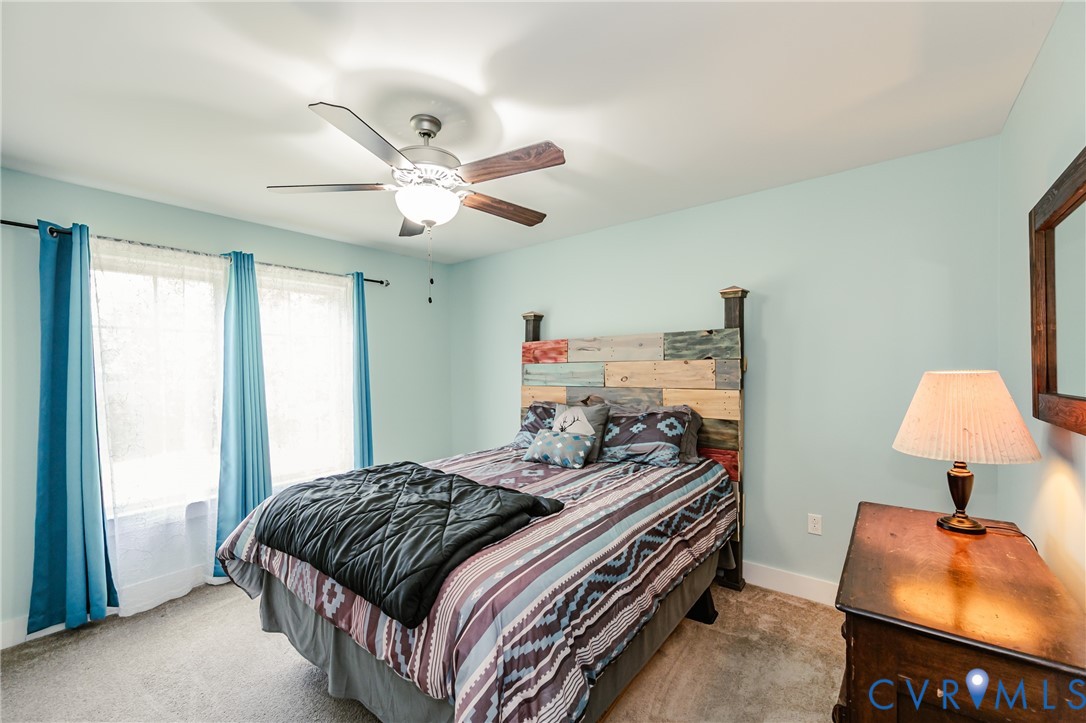 915 Manchester Road Bumpass, VA 23024 - Photo 32 of 49 a bedroom with a bed and a chandelier