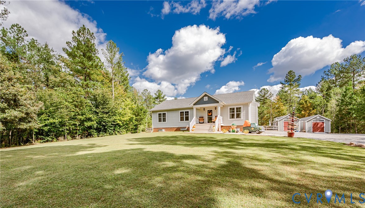 915 Manchester Road Bumpass, VA 23024 - Photo 35 of 49 a view of a white house with a big yard and large trees