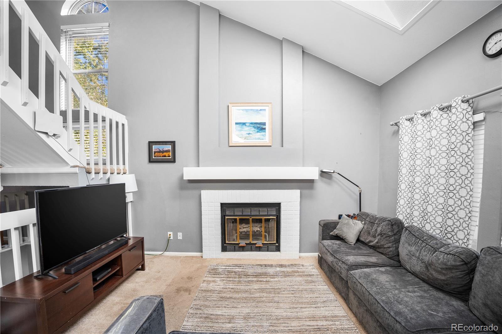 8567 Rabbitbrush Way Parker, CO 80134 - Photo 15 of 46 a living room with furniture a flat screen tv and a fireplace