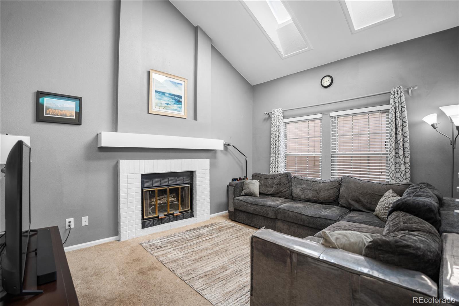 8567 Rabbitbrush Way Parker, CO 80134 - Photo 17 of 46 a living room with furniture and a fireplace