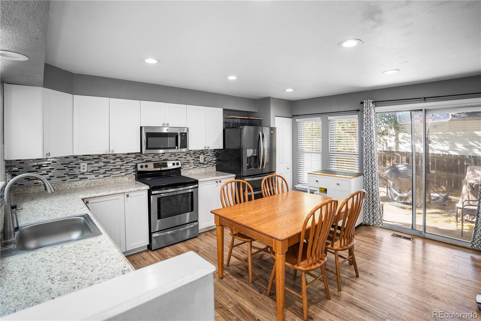 8567 Rabbitbrush Way Parker, CO 80134 - Photo 18 of 46 a kitchen with a table chairs microwave and refrigerator