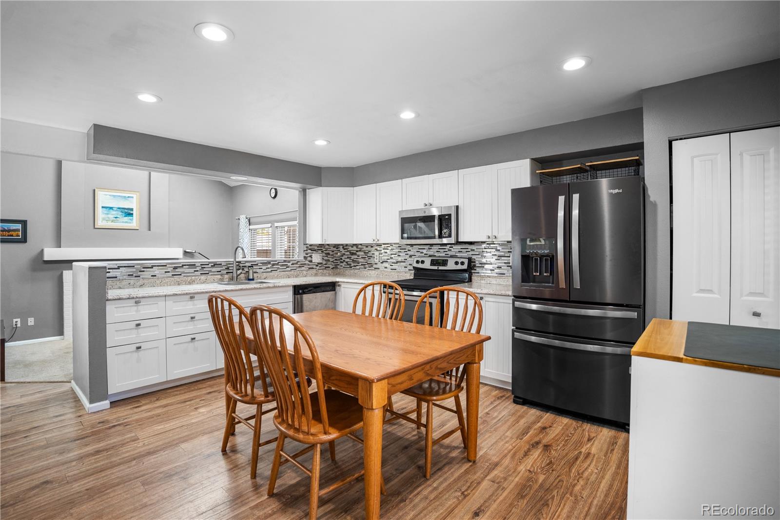 8567 Rabbitbrush Way Parker, CO 80134 - Photo 20 of 46 a kitchen with granite countertop a refrigerator stove microwave and cabinets