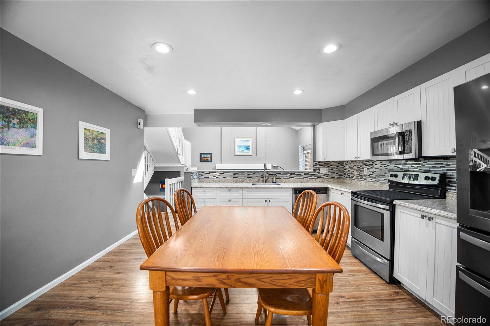8567 Rabbitbrush Way Parker, CO 80134 - Photo 21 of 46 a kitchen with granite countertop white cabinets and stainless steel appliances
