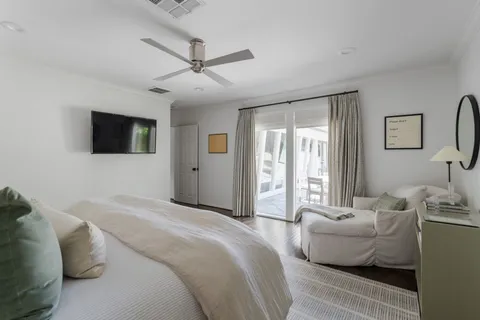 a bedroom with a bed a window and a flat screen television