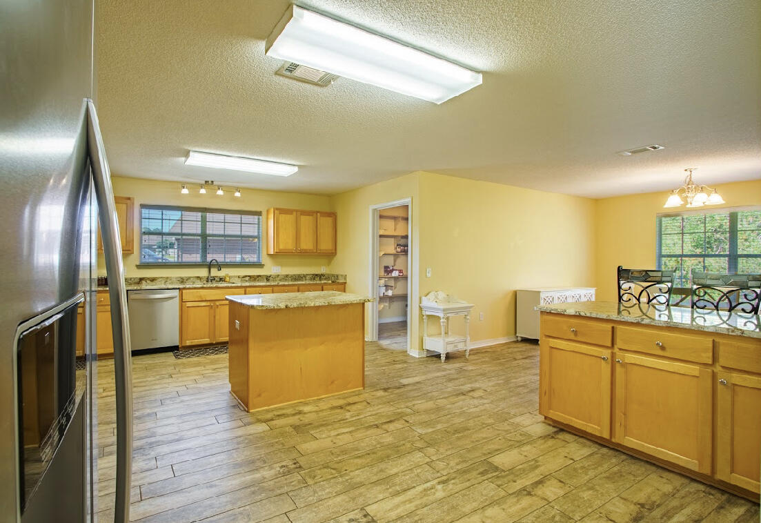 232 Raptor Drive Crestview, FL 32536 - Photo 16 of 42 a large kitchen with cabinets and wooden floor