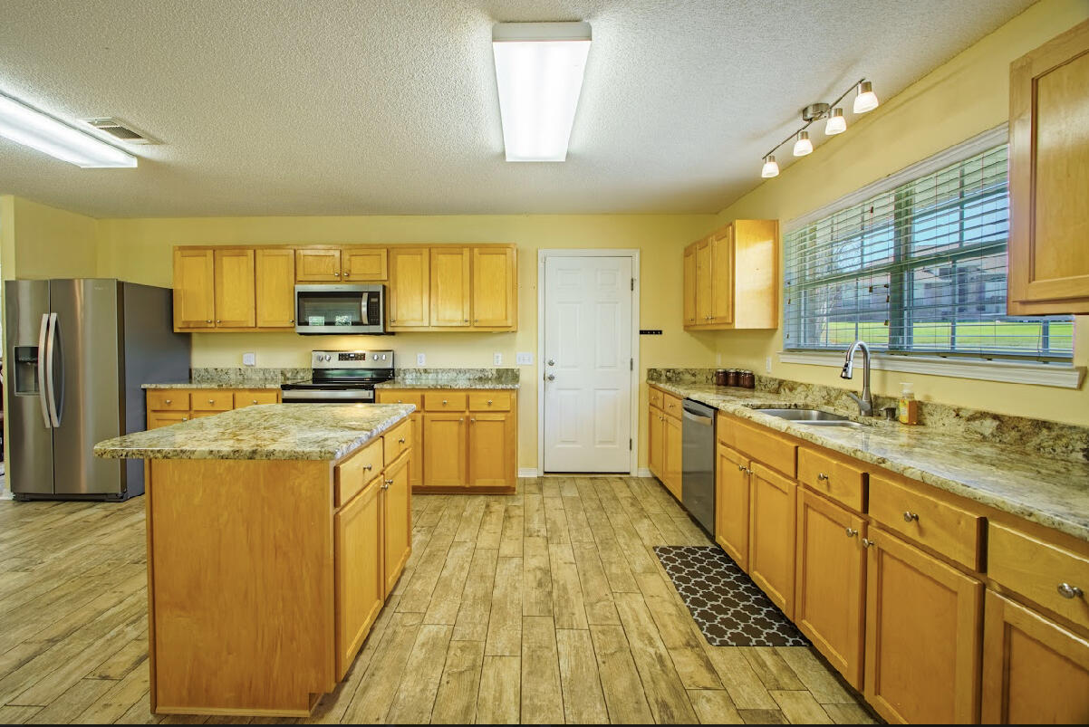 232 Raptor Drive Crestview, FL 32536 - Photo 17 of 42 a kitchen with stainless steel appliances a stove a sink dishwasher a refrigerator and a oven with wooden floor