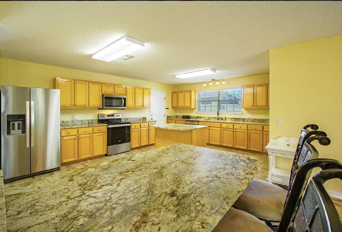 232 Raptor Drive Crestview, FL 32536 - Photo 18 of 42 a kitchen with stainless steel appliances kitchen island granite countertop a sink and cabinets