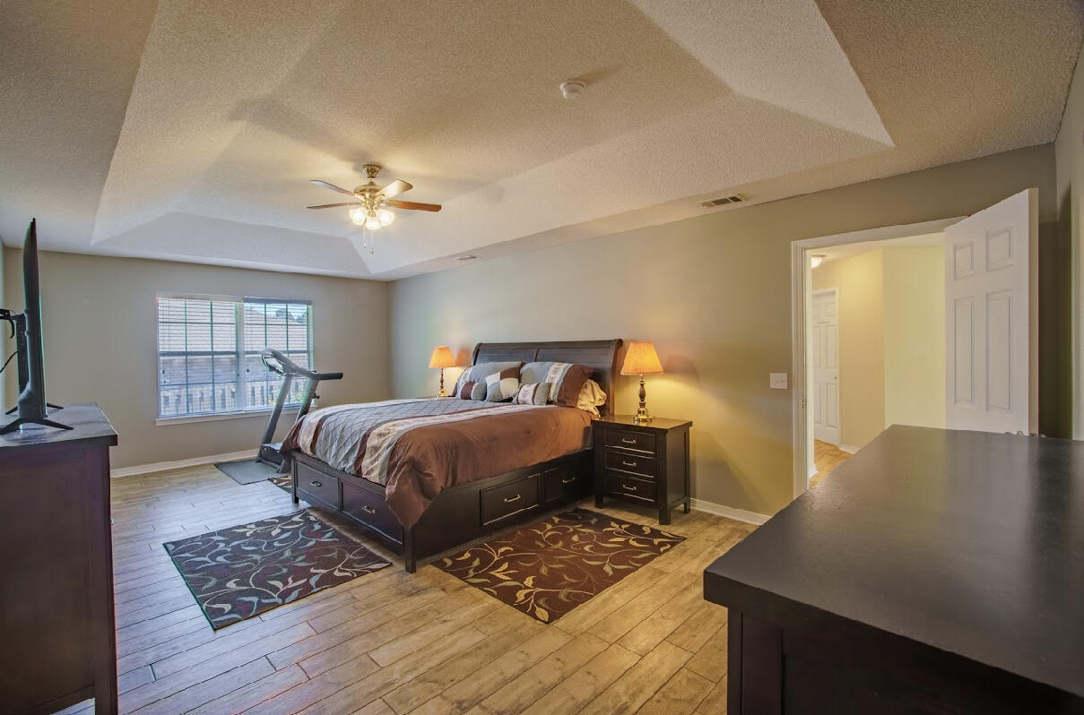 232 Raptor Drive Crestview, FL 32536 - Photo 29 of 42 a bedroom with a bed lamps and wooden floor