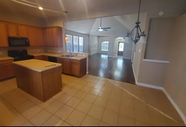 a kitchen with stainless steel appliances granite countertop a sink a stove top oven a counter space and cabinets