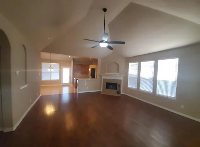 a view of an empty room with a fireplace and a window