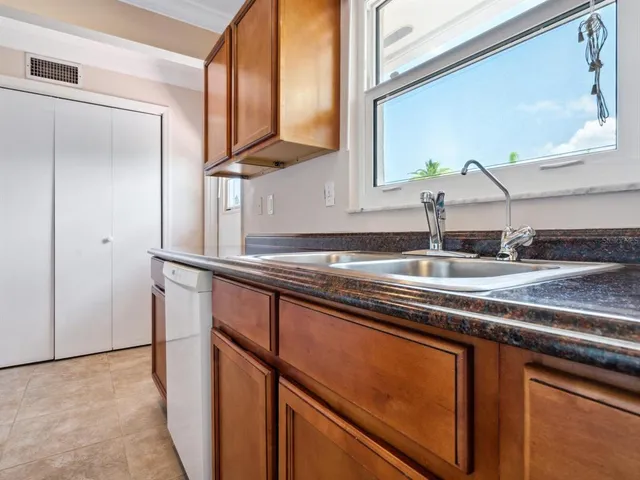 a kitchen with stainless steel appliances granite countertop a sink and a refrigerator