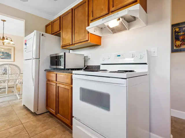 a kitchen with stainless steel appliances granite countertop a refrigerator sink stove and white cabinets