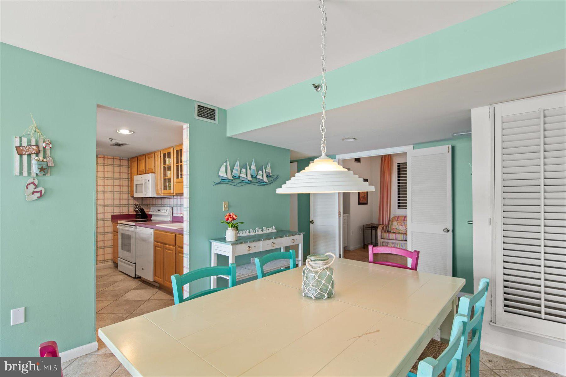 907 Georgetown House, Unit PH07 Bethany Beach, DE 19930 - Photo 15 of 48 a kitchen with stainless steel appliances kitchen island a table and chairs